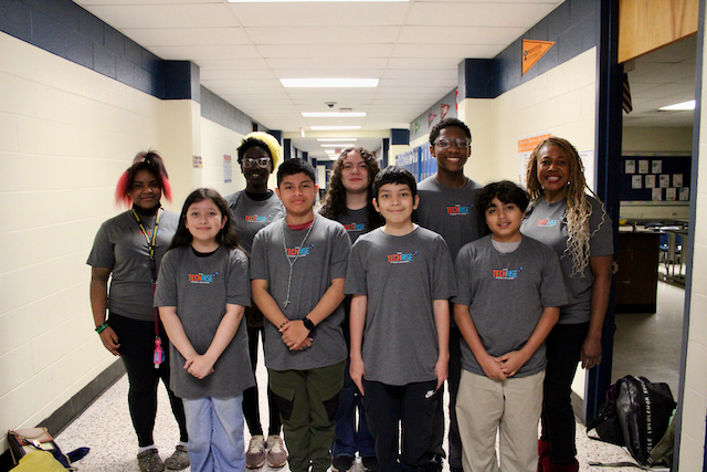  Members of the Albemarle Road Middle School Science Club and their teacher pose together